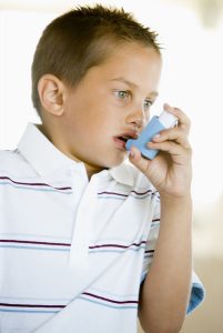 Boy with asthma using inhaler