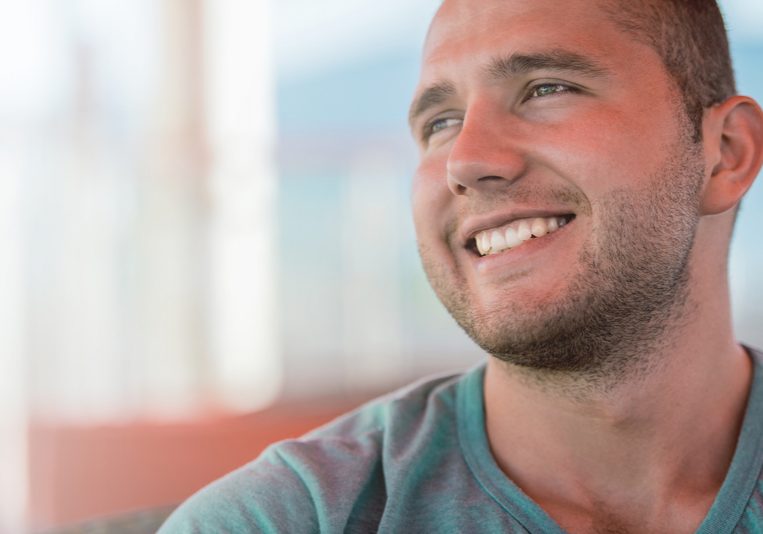 portrait of a happy young man in green t-shirt