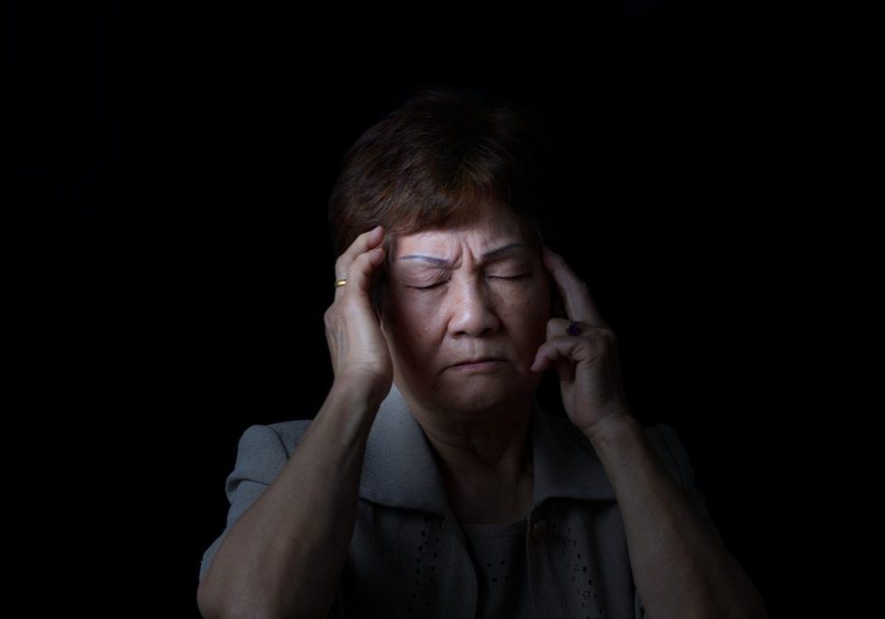 woman with headache who needs a chiropractic adjustment